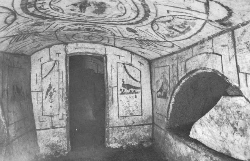 Photographie en noir et blanc d'une catacombe juive antique avec des fresques murales et au plafond représentant des motifs géométriques et des paons.