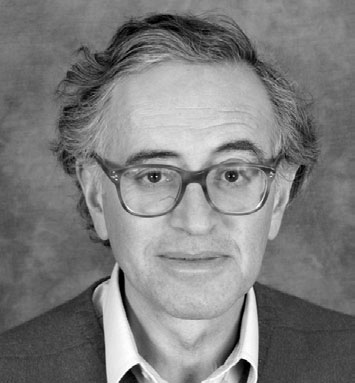 Photographic portrait of Daniel Oppenheim, in a dark suit and glasses.